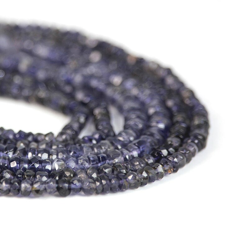 May include: A strand of dark blue faceted gemstone beads. The beads are small and have a slightly irregular shape.