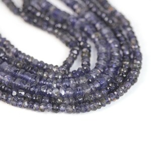 May include: A strand of dark blue faceted gemstone beads. The beads are small and have a slightly irregular shape.