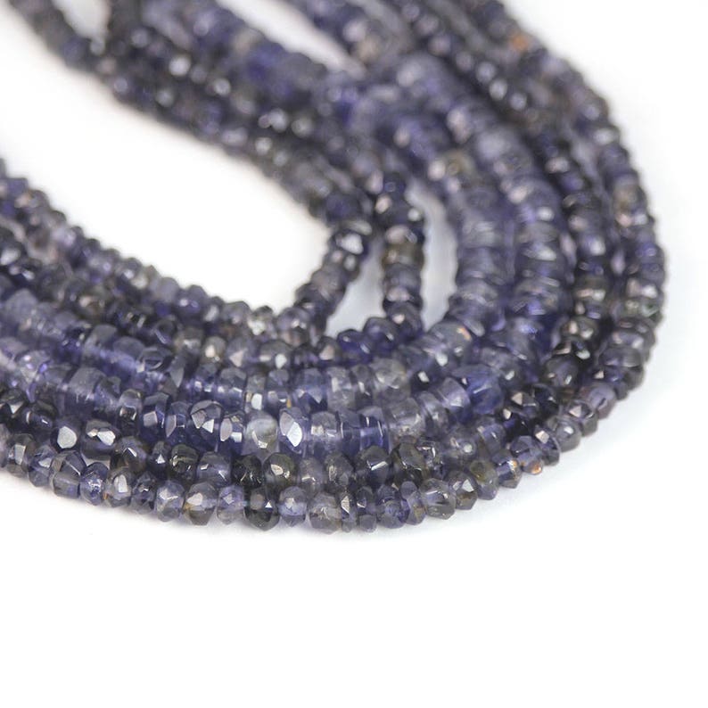 May include: A strand of dark blue faceted gemstone beads. The beads are small and have a slightly irregular shape.