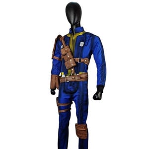 May include: Blue jumpsuit with yellow and brown accents, featuring a zip-up front and multiple brown leather pouches and straps. The costume includes a belt, shoulder strap, and knee pads. The outfit is displayed on a black mannequin.