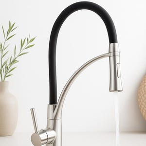 Könnte beinhalten: Ein moderner Küchenarmatur mit gebürsteter Nickeloberfläche und einem schwarzen, flexiblen Auslauf. Wasser fließt aus dem Wasserhahn in ein Edelstahlbecken. Der Wasserhahn verfügt über einen Einhebelmischer und einen ausziehbaren Sprüher.