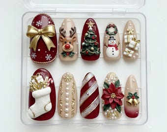 May include: A set of ten Christmas-themed press-on nails in a clear plastic case. Designs include a gold bow, reindeer, Christmas tree, snowman, gifts, stocking, snowflakes, candy cane stripes, poinsettia, and bells.