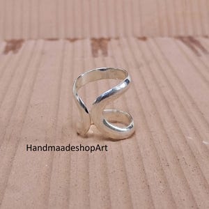 大きな抽象的なスターリングシルバーリング、滑らかで流れるようなライン、ポリッシュ仕上げ