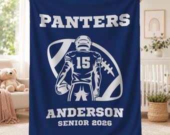 May include: A navy blue fleece blanket featuring a white graphic of a football player wearing jersey number 15, positioned in front of a large football outline. The text reads PANTERS, ANDERSON, and SENIOR 2026 in bold white block lettering.