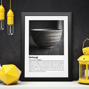 K&ouml;nnte beinhalten: Ein gerahmter Schwarz-Wei&szlig;-Druck einer japanischen Kintsugi-Schale mit goldenen Akzenten. Das Bild wird auf einer wei&szlig;en Oberfl&auml;che mit gelben Dekorationselementen, darunter eine Laterne und H&auml;ngelampen, pr&auml;sentiert.