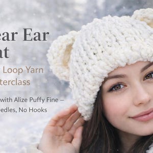 May include: A white, chunky-knit bear ear hat. The hat is made with loop yarn and features two bear ears on top. Text on the image reads "Bear Ear Hat, Easy Loop Yarn Masterclass, Made with Alize Puffy Fine - No Needles, No Hooks."