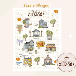 Puede incluir: Una ilustración en acuarela con varios edificios y lugares emblemáticos de la ciudad ficticia de Stars Hollow, incluyendo el Diner de Luke y la casa de Lorelai. El diseño incluye calabazas, estrellas y el texto "Atelier Gilmore."