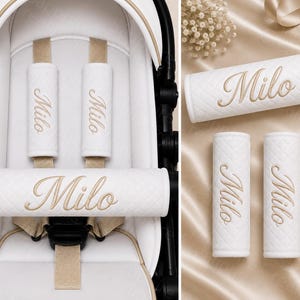 May include: A set of white stroller strap covers and a bumper bar cover featuring a quilted texture and the name Milo embroidered in gold thread. The covers are shown attached to a white stroller and displayed separately on a satin surface.