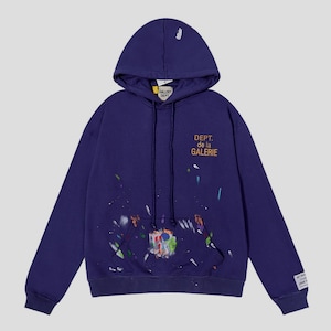 Peut inclure: Un sweat &agrave; capuche bleu marine avec une capuche &agrave; cordon et une poche kangourou. Le devant porte l'inscription "DEPT. de la GALERIE" en orange, avec des &eacute;claboussures de peinture color&eacute;es. Une petite &eacute;tiquette est sur la manche gauche. Le sweat est ample.