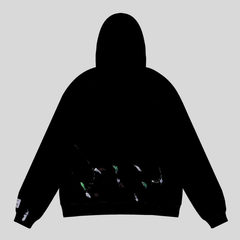 Peut inclure: Sweat-shirt &agrave; capuche noir avec un motif &eacute;claboussures de peinture blanche, verte et marron. Le sweat-shirt a une capuche et des manches longues. Une petite &eacute;tiquette blanche est sur la manche gauche.