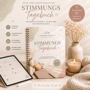May include: A spiral-bound journal with the title "Stimmungs Tagebuch" in a handwritten font, alongside a tablet and decorative items. The journal's cover features a heart design and the text "Für mehr Achtsamkeit, Selbstliebe und innere Balance."