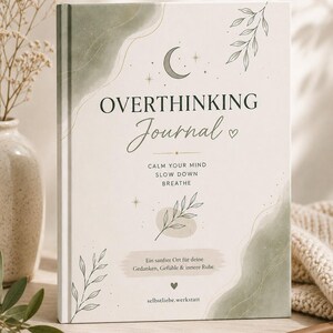 Könnte beinhalten: Ein Hardcover-Journal mit dem Titel "OVERTHINKING Journal" in eleganter Schrift. Das Cover zeigt einen Mond, Sterne und botanische Illustrationen in sanften Grün- und Beigetönen. Der Text "CALM YOUR MIND, SLOW DOWN, BREATHE" ist ebenfalls sichtbar.