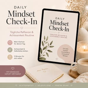 May include: A digital tablet shows "Daily Mindset Check-In" with German text. A spiral-bound notebook with "me time" is open next to a pen. A cup of coffee and a candle are also visible.