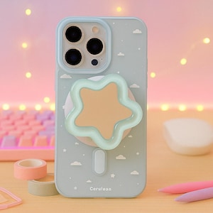 Peut inclure: Une coque de téléphone bleu clair avec une poignée en forme d'étoile. L'étui a un fond bleu clair avec des nuages et des étoiles blancs. La poignée en étoile est de couleur pêche avec un contour vert clair. Le mot "Cerulean" est imprimé en bas.