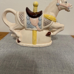 May include: A trio of ceramic mugs with a speckled, matte finish in cream, light grey, and dark grey. Each mug features a simple, minimalist design and a rounded handle.
