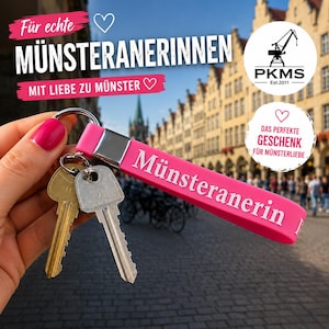 Könnte beinhalten: Ein pinker Silikon-Schlüsselanhänger mit einem silbernen Metallverbinder und einem Schlüsselring, an dem zwei Metallschlüssel hängen. Der Anhänger trägt den weißen Schriftzug 'Münsteranerin'. Das Design ist schlicht, funktional und langlebig.