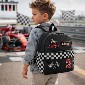 Puede incluir: Mochila negra con temática de carreras. Presenta un patrón de cuadros, un coche de carreras rojo y el número 3. Incluye un parche con el nombre "Liam".