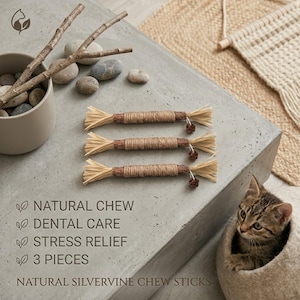 May include: Three natural silvervine chew sticks for cats. Each stick is wrapped in twine with a raffia end and a small decorative element. The image also includes a kitten in a cat bed and text that reads "Natural Chew, Dental Care, Stress Relief, 3 Pieces, Natural Silvervine Chew Sticks."
