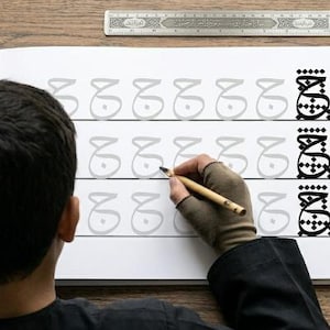 Könnte beinhalten: Ein Übungsheft für arabische Kalligrafie mit Zeilen des Buchstabens Jeem in Hellgrau zum Nachspuren, wobei am Ende jeder Zeile ein fertiges schwarzes Beispiel steht. Ein 30 cm langes Metalllineal liegt oben auf dem aufgeschlagenen Buch.
