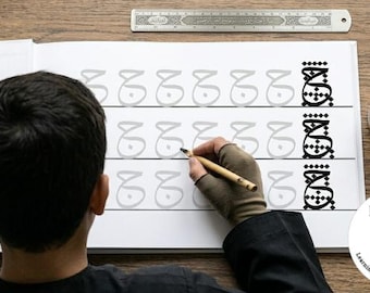 May include: A white practice workbook featuring rows of the Arabic letter Jeem in light gray for tracing, with a completed black version at the end of each row. A 12-inch metal ruler is positioned at the top, and a wooden pen rests in an inkwell.