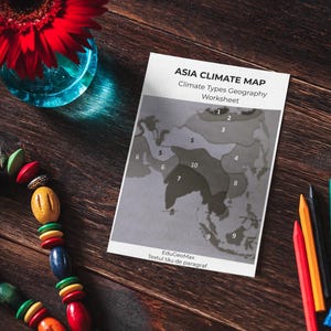 Op de afbeelding: Een stilleven met een rode gerbera in een blauwe vaas, een kleurrijke kralenketting, een kaart met de titel "ASIA CLIMATE MAP" en verschillende kleurpotloden. De kaart is een aardrijkskunde werkblad.