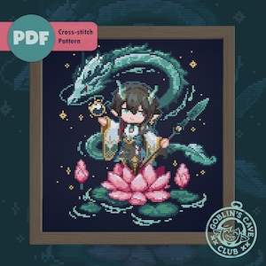 Könnte beinhalten: Kreuzstichmuster mit einer Fantasy-Figur auf einer rosa Lotusblume, mit einem grünen Drachen und dem Text "PDF Cross-stitch Pattern". Das Kunstwerk ist in einem Holzrahmen gerahmt und enthält das Logo "Goblin's Cave Club".