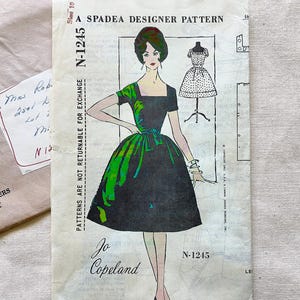 May include: A Spadea Designer Pattern N-1245 sewing pattern envelope featuring an illustration of a dress with a black bodice and a green and black patterned skirt. The text reads A Spadea Designer Pattern, N-1245, Jo Copeland, and Size 10.