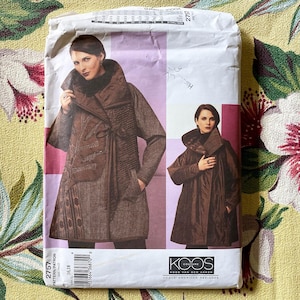 May include: A Vogue Patterns sewing pattern envelope labeled 2757 featuring a Koos Couture design. The front displays two images of a brown jacket with a high collar, long sleeves, and a tie closure. The text includes Vogue American Designer.