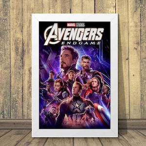 Może przedstawiać: Oprawiony plakat do filmu Avengers: Endgame z Marvel Studios. Plakat przedstawia kolaż postaci, w tym Iron Mana, Thora i Kapitana Amerykę, na fioletowo-niebieskim tle. Tytuł "Avengers Endgame" jest wyraźnie widoczny.