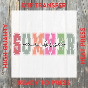 May include: A white square with the words "SUMMER vibes" in colorful block letters. The word "SUMMER" is in red, green, orange, pink, and green. The word "vibes" is in a cursive font with a heart above the "i".