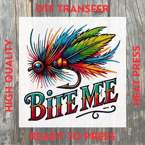 May include: A colourful DTF transfer featuring a detailed fly fishing lure design with the text "BITE ME." The design includes vibrant hues of blue, green, orange, and red. The words "HIGH QUALITY," "HEAT PRESS," and "READY TO PRESS" are also visible.