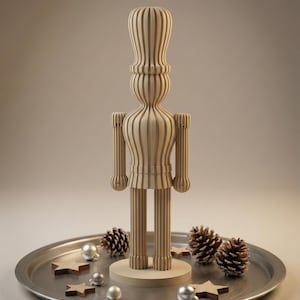 May include: A wooden nutcracker figurine with vertical striped detailing stands on a silver tray. The tray is decorated with pine cones, silver baubles, and wooden star-shaped decorations. The figurine is light brown.