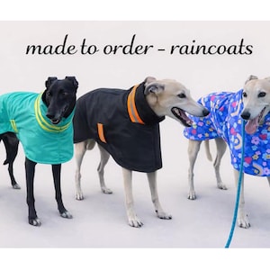 May include: Three greyhound dogs wearing raincoats with the text made to order - raincoats. One dog wears a teal coat with yellow stripes, one wears a black coat with orange reflective strips, and one wears a blue coat with a colourful floral pattern.