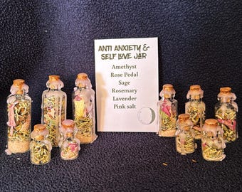Può includere: Una collezione di piccoli vasetti di vetro con tappi di sughero, riempiti con varie erbe essiccate e sale rosa. I vasetti sono disposti attorno a un cartoncino con la scritta "Anti Anxiety & Self Love Jar" con un elenco di ingredienti.
