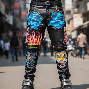 May include: Black leather pants with blue camouflage patches, flame and tiger patches, and gold zippers. The pants have a black belt and are worn with black shoes.