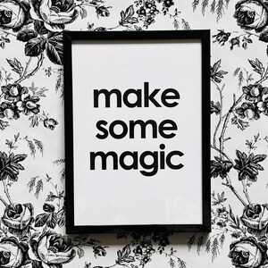 May include: Black and white framed print with the text "make some magic" on a white background. The print is on a white background with a black and white floral pattern.