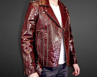 Puede incluir: Chaqueta de cuero burdeos con textura de piel de cocodrilo. La chaqueta presenta un estilo motero clásico con cuello de solapa, cremallera asimétrica y múltiples bolsillos. Se lleva sobre una camiseta blanca.