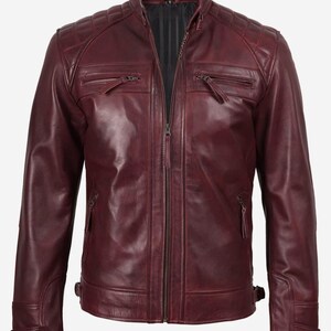 Puede incluir: Chaqueta de cuero burdeos con dise&ntilde;o acolchado en los hombros y cuello alzado. La chaqueta presenta cierre de cremallera frontal, m&uacute;ltiples bolsillos con cremallera y correas laterales ajustables. Un estilo cl&aacute;sico.