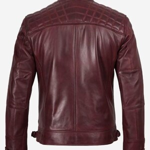 Puede incluir: Chaqueta de cuero burdeos con dise&ntilde;o acolchado en hombros y espalda. La chaqueta tiene cuello alzado, dos bolsillos delanteros y correas ajustables en la cintura. Las mangas tienen coderas acolchadas.