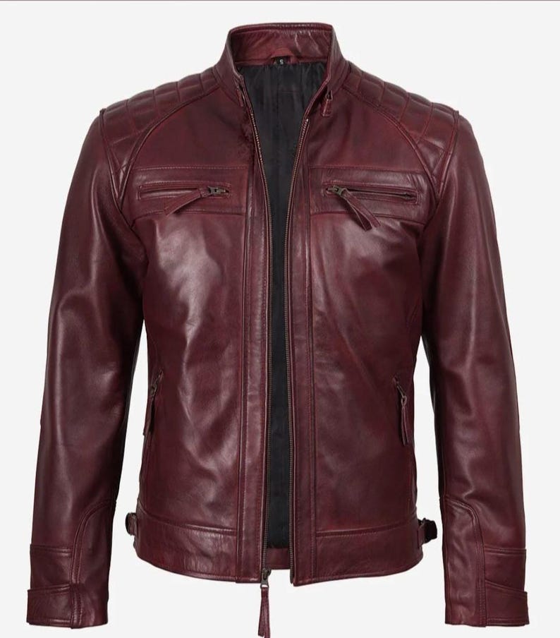 Puede incluir: Chaqueta de cuero burdeos con dise&ntilde;o acolchado en los hombros y cuello alzado. La chaqueta presenta dos bolsillos con cremallera en el pecho, dos bolsillos inferiores con cremallera y cierre frontal con cremallera. Las mangas tienen pu&ntilde;os con cremallera y pesta&ntilde;as laterales ajustables.