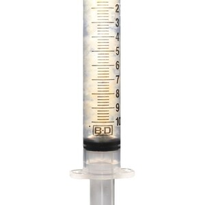 May include: A clear plastic syringe with a beige cap and a black and white label that reads "B-D". The syringe is filled with a clear liquid and has markings up to 10 milliliters.