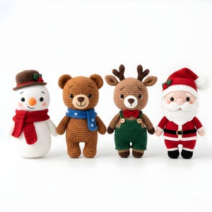 Pode incluir: Quatro personagens de Natal feitos &agrave; m&atilde;o em croch&ecirc;: um boneco de neve com chap&eacute;u castanho e cachecol vermelho, um urso castanho com cachecol azul, uma rena com macac&atilde;o verde e gravata borboleta, e o Pai Natal com fato e chap&eacute;u vermelhos.