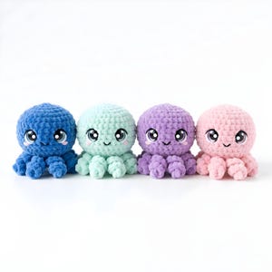 Pode incluir: Quatro brinquedos de polvo de croch&ecirc; feitos &agrave; m&atilde;o em fila. Cada polvo tem uma cor pastel diferente: azul, verde menta, roxo e rosa. Eles t&ecirc;m olhos grandes e expressivos e rostos sorridentes, perfeitos para um brinquedo infantil ou decora&ccedil;&atilde;o de ber&ccedil;&aacute;rio.