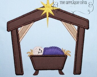 May include: A brown wooden manger with a baby Jesus inside, sleeping under a purple blanket. A yellow star shines above the manger.