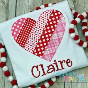 May include: White t-shirt with a red, pink, and white patchwork heart design and the name "Claire" embroidered in red below it.