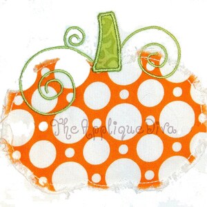 May include: Orange and white fabric pumpkin with a green stem and swirls. The pumpkin is decorated with white polka dots on an orange background.