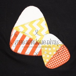 May include: A candy corn applique design with a white, yellow, orange, and red patchwork pattern. The applique is stitched with a zig-zag stitch around the edges.