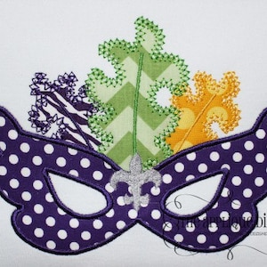 May include: Purple and white polka dot masquerade mask with green, yellow, and purple leaves and a silver fleur-de-lis design.