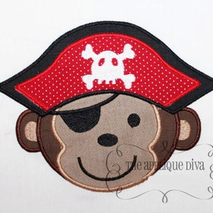 May include: Embroidered applique of a brown monkey wearing a red and black pirate hat with a white skull and crossbones design.