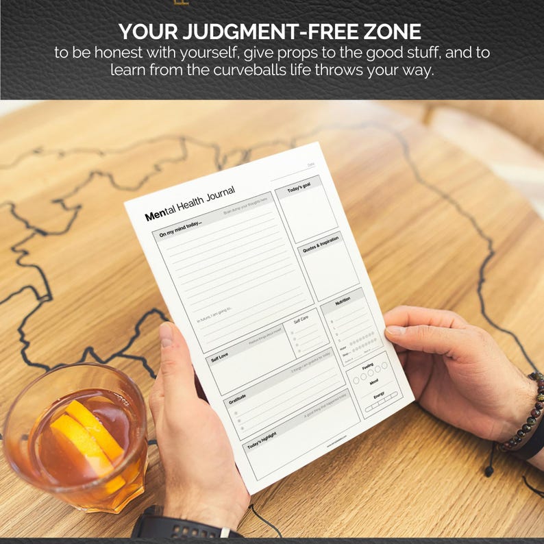 May include: A white Mental Health Journal with sections for daily entries, held over a wooden table. The journal includes sections for goals, quotes, self-care, and gratitude. The text "YOUR JUDGMENT-FREE ZONE" is at the top.